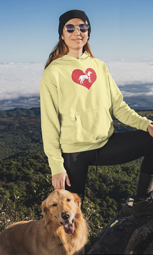 A woman wearing a yellow sweatshirt with the I love guide dogs symbol