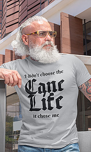 An older man wearing a gray shirt with I didn't choose the cane life -it chose me