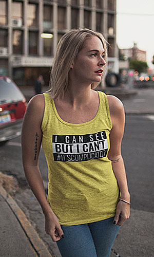 A woman wearing a yellow tank top with I can see But I can't #ItsComplicated